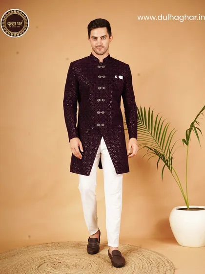 A striking Indo-Western sherwani in deep purple, featuring a geometric pattern and ornate buttons. It's a powerful look for a groom who wants to blend tradition with a bold, modern statement.