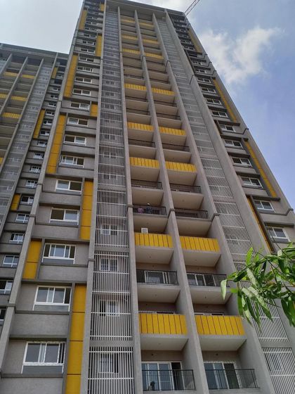 An upward-looking perspective of the Salarpuria Sattva Opus apartments, detailing the balcony design and the vertical fins that add texture to the building's face.