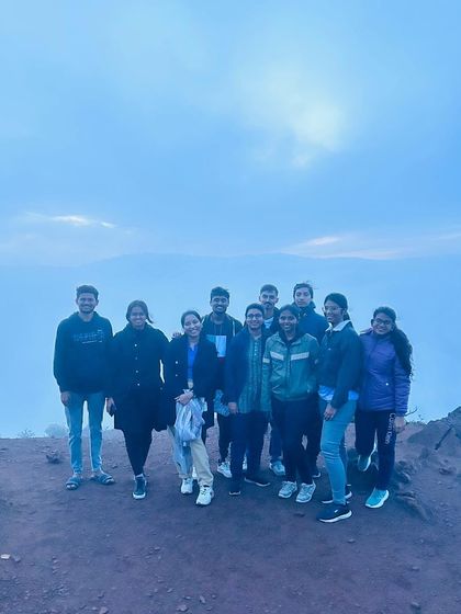 The group at a viewpoint just as the fog begins to clear, revealing the landscape.