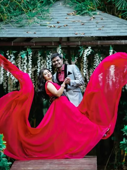 A beautiful pre-wedding photo in a garden gazebo. The "flying" red trail creates a stunning frame around the couple.