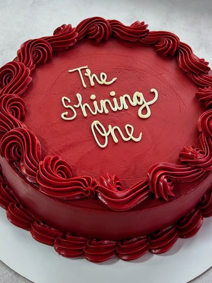This bold red cake is called "The Shining One." Underneath the rich buttercream is a delicious chocolate raspberry filling, making it as decadent as it looks.