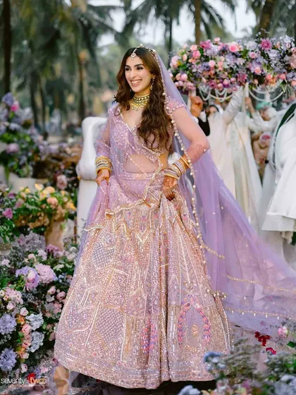 The bride's grand entrance at her Goa wedding, carried in under a beautiful floral canopy, looking radiant and joyful.