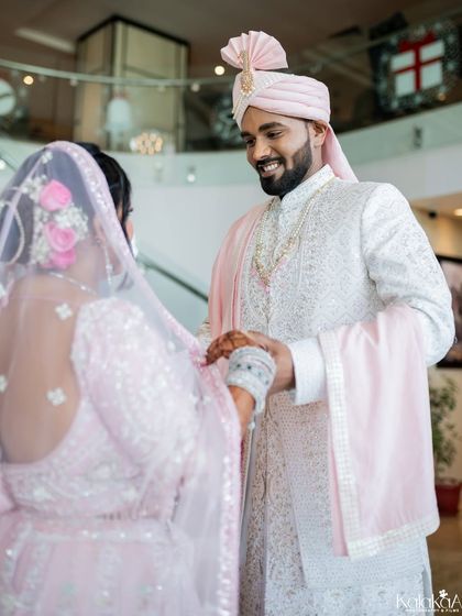 A sweet, candid moment between the bride and groom. The groom's happy smile as he holds his bride's hand shows the connection and excitement that fills the wedding day.