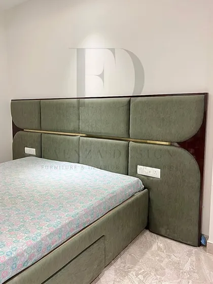 A custom-made bed with a unique headboard design. It combines olive-green upholstered panels with a high-gloss wood frame and a central brass accent, showcasing a sophisticated mix of materials.