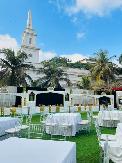 A wide shot of the beautiful outdoor venue, showing our catering stations seamlessly integrated with the elegant white-themed decor.