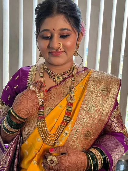 Adjusting the beautiful pearl mundavalya, a significant part of the Maharashtrian bridal look.