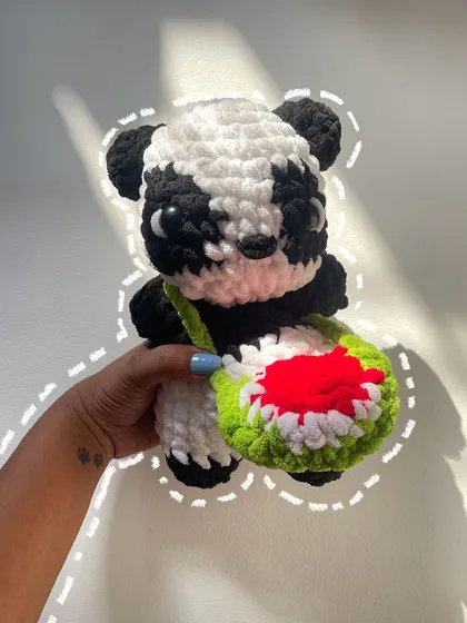A cute panda plushie saying hi. This little guy is complete with a watermelon-slice bag, a fun and quirky custom detail requested by the client.