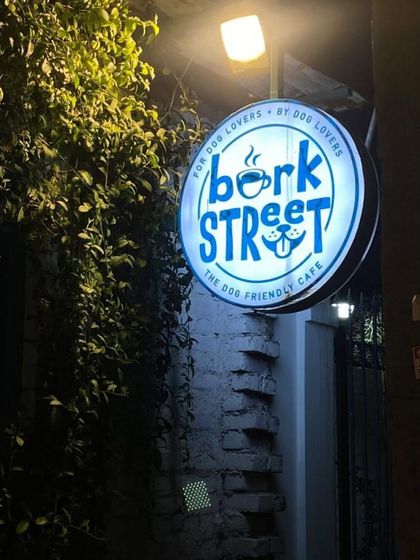 Our cafe sign lit up at night, welcoming everyone to our dog-friendly space.