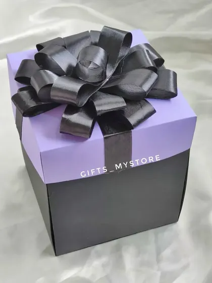 The elegant purple and black packaging of my budget-friendly Dairy Milk chocolate explosion box, topped with a big black bow.