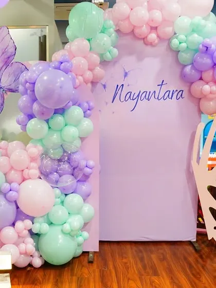 Welcome to the enchanted forest. This Fairy Garden theme features a beautiful butterfly-wing entrance, mushroom props, and a soft, magical color palette of pastel balloons.