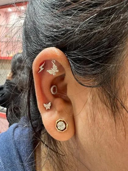 A playful and trendy ear stack featuring lightning bolt and butterfly studs, perfect for a youthful and energetic vibe.