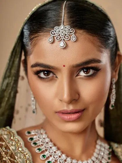 A close-up of a glamorous bridal look. The sharp winged liner and perfectly sculpted brows frame the face, while the skin remains fresh and dewy.