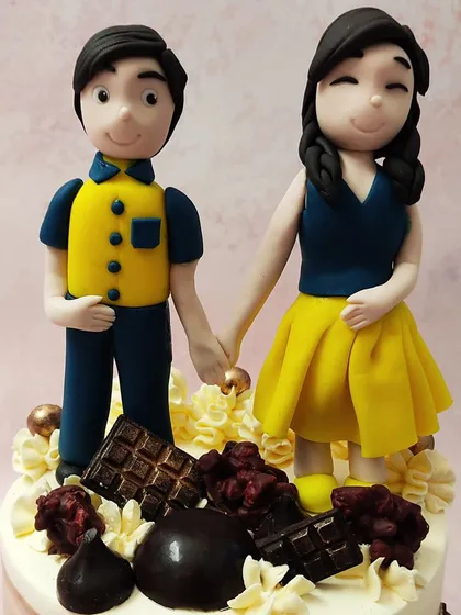 A close-up of our custom couple anniversary cake topper, showing a sweet, hand-in-hand moment captured in fondant.