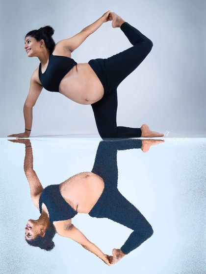 A playful and creative reflection shot. This image captures a mom-to-be doing a yoga pose, with her reflection creating a perfectly symmetrical and visually interesting portrait.
