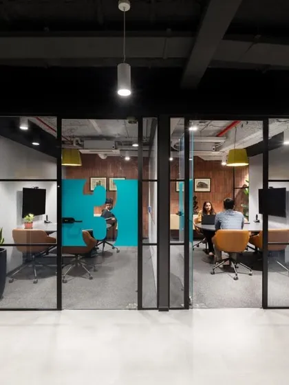 A pair of glass-fronted meeting rooms, each with a slightly different interior design. This provides variety and choice for employees.