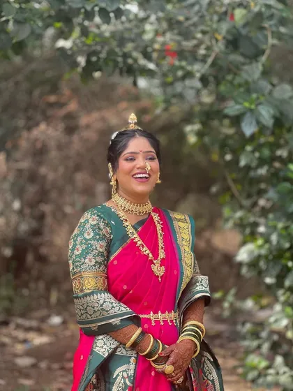 A happy bride in her pink and green Nauvari. The makeup is fresh and glowing, enhancing her natural beauty and joyful expression.