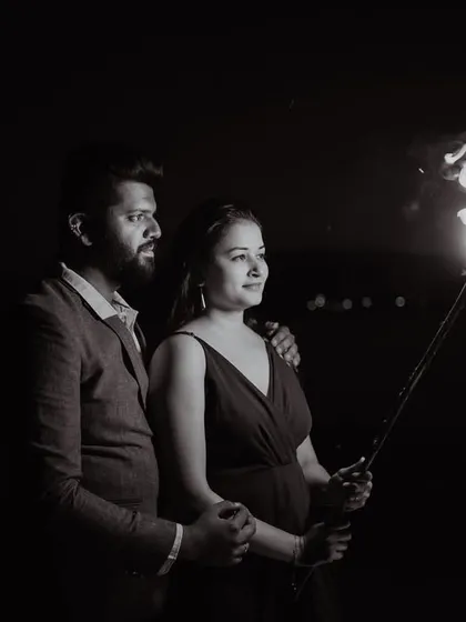 Another perspective of the dramatic fire torch pre-wedding shoot. This black and white image highlights the bride's profile and the flickering flame, creating a timeless and artistic portrait.