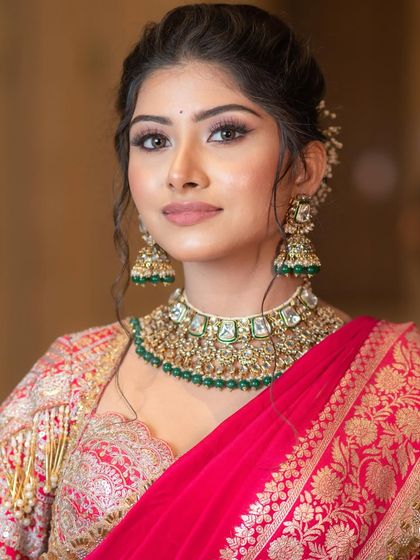 A close-up of the regal makeup. I paired a classic winged liner and a soft nude lip with the bold red saree and green jewelry, creating a look that is balanced and sophisticated.