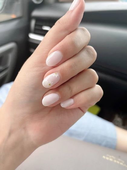 Are you obsessing over your nails this weekend? A clean and chic milky white manicure with delicate daisy sticker accents.