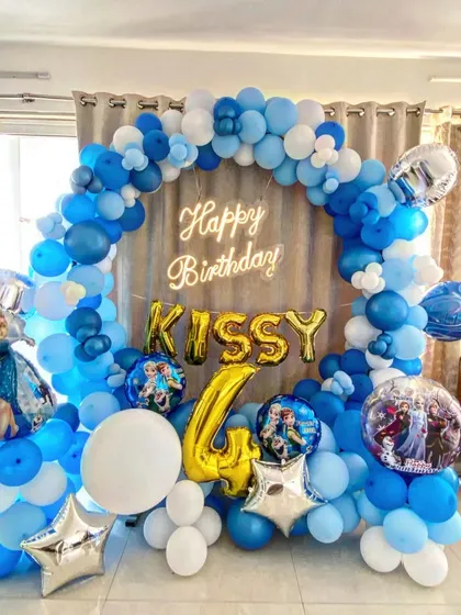 A beautiful Frozen-themed 4th birthday party, featuring a blue and white balloon ring backdrop with Elsa and other character foil balloons.
