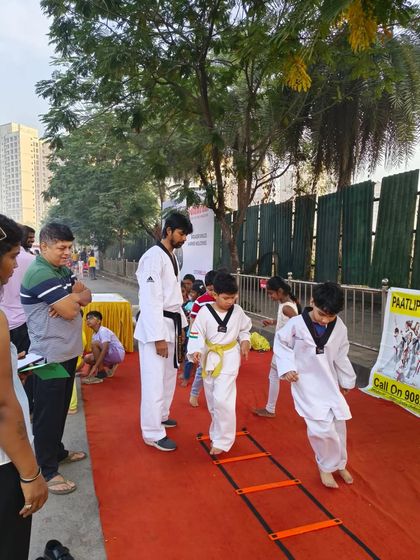 Taking our training outdoors. A young student practices on an agility ladder during our session at the Malad Masti event, showing that we can build skills anywhere.