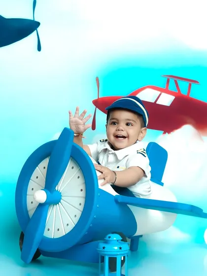 Let your child's imagination take flight with a themed photoshoot. This little one is ready for takeoff in our adorable pilot costume and airplane prop, set against a sky full of adventure.