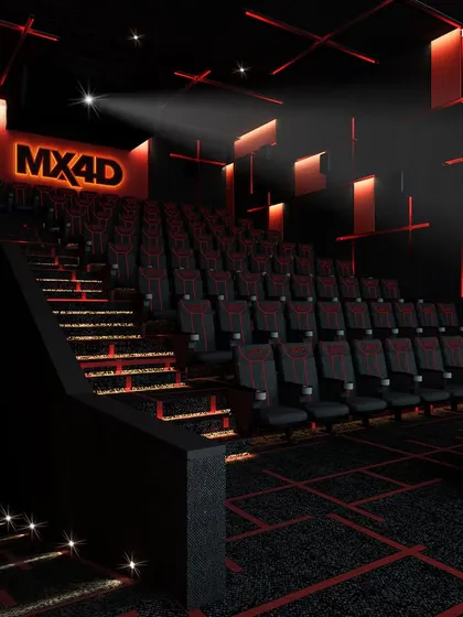 A private cinema designed with a futuristic and edgy aesthetic. The all-black interior is punctuated by red accent lighting on the walls and stairs, creating a dramatic and immersive environment for watching movies.