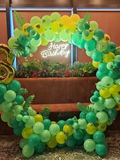 This jungle-themed circular balloon arch uses various shades of green to create a lush, leafy effect. I added a gold foil number '8' and a "Happy Birthday" neon sign to make it a perfect, on-theme photo booth for the party.