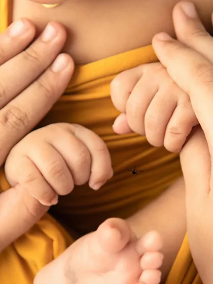 A touching photo of a newborn's hands held securely by her parents. It’s a powerful symbol of family, love, and protection.