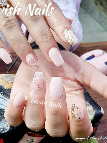 A soft and romantic set with matte pink nails, gold foil, and a transparent accent nail with a delicate heart design.