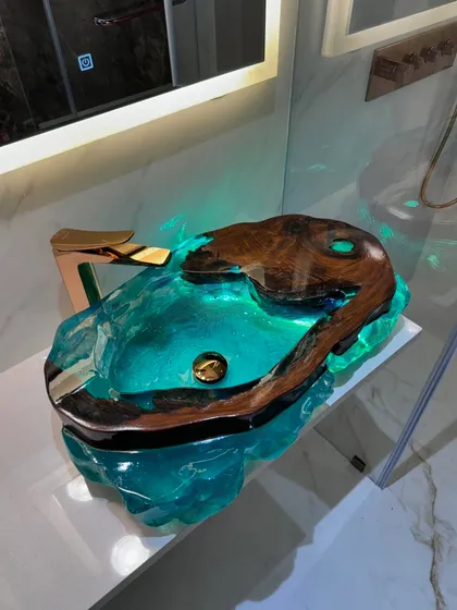 Another angle of the exclusive live-edge wood and blue resin washbasin, showing how the light illuminates the piece from within.