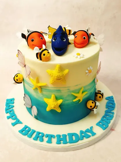 We bring the ocean to life with this Finding Dory cake, featuring Dory, Nemo, and Marlin swimming amongst bees and starfish on an ombre blue base.