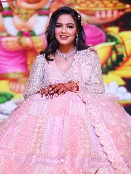 A seated portrait of the engagement bride, looking absolutely regal. The grand backdrop complements her stunning pink lehenga and the soft, glamorous makeup.