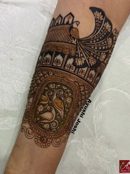 A close-up of the arm band, showing the vibrant colors of the half-dry, half-fresh henna.