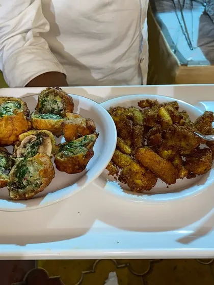 We offer a wide variety of starters to suit every palate. This tray features our crispy stuffed bread rolls and another fried specialty, served with a spicy dipping sauce.