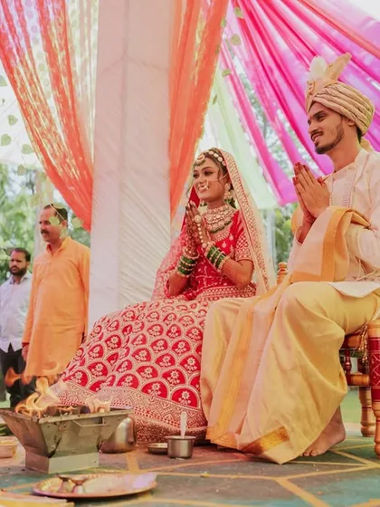 A wider angle of the couple seated at the mandap, participating in the wedding rituals.