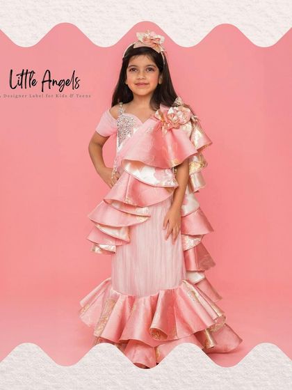 This jacquard drape saree in pink and gold features dramatic ruffles, offering a high fashion take on ethnic wear.