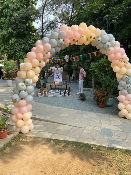 A large pastel balloon arch at the entrance of an outdoor party venue.