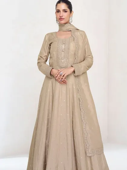 This beige premium silk gown is the definition of understated elegance. The delicate thread embroidery and sequins add a touch of sparkle, making it perfect for a reception or evening party.