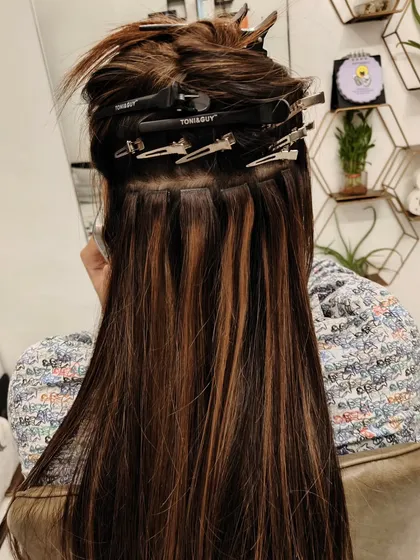 Here you can see the tape-in wefts during application. They are placed strategically to add volume and highlights throughout the hair.