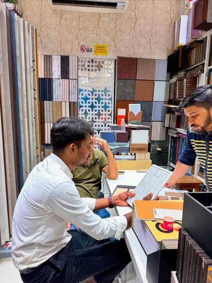 A wider view of the material selection process, surrounded by samples of laminates, veneers, and decorative panels.