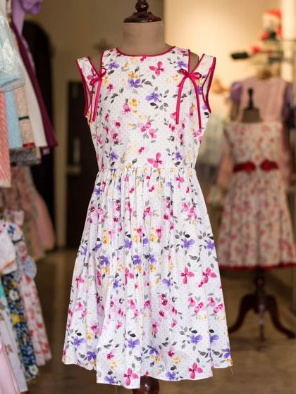 This floral dress with shoulder-tie details is a perfect example of playful elegance. The vibrant pink ribbons add a fun pop of color against the delicate print.