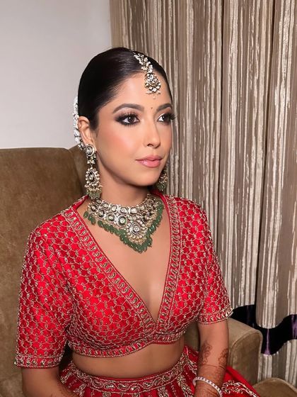A classic bridal portrait with kohl-lined eyes and a dewy skin finish. This look is perfect for the traditional Indian bride who wants to look elegant and timeless in her red Sabyasachi lehenga.