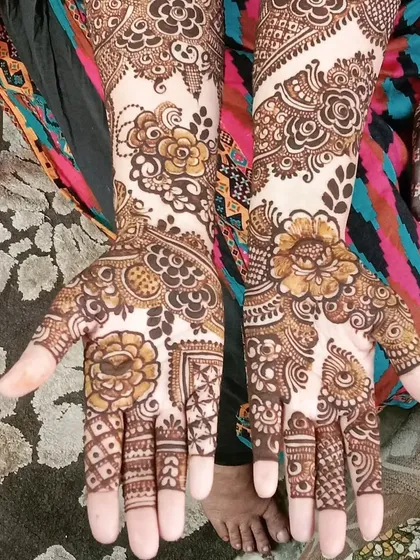 This full-hand design showcases a mix of bold flowers and delicate leaf patterns, with detailed work covering each finger.