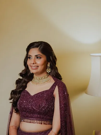 A close-up of Kajol's Sangeet glam. We used warm tones on her eyes and a matching lip color to complement her gold jewelry.