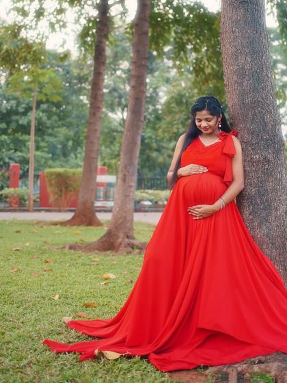 This comfortable and flowy red one-bow maternity gown is perfect for outdoor photoshoots. Its simple elegance allows your natural glow to shine through.