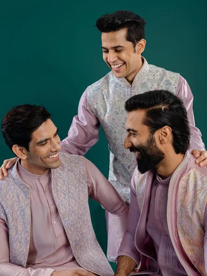 Three men share a laugh, showcasing our versatile collection of pastel Jawahar jackets. Each piece, though similar in color, features a unique embroidery pattern, reflecting individual style.