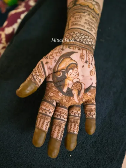 A detailed close up of a baby shower figure. This palm features a sweet drawing of a baby sleeping peacefully on a crescent moon, surrounded by hanging stars.