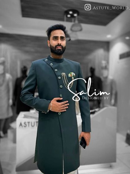 A client in a dark teal asymmetrical Indo-Western sherwani. The clean lines and unique buttoning make it a modern and minimalist statement piece.