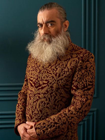 A closer look at the intricate gold embroidery on the rich maroon velvet. The craftsmanship is evident in every single stitch, creating a texture that is as luxurious to the touch as it is to the eye.